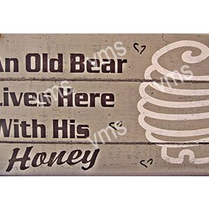 Rustic wooden sign about a bear and honey.