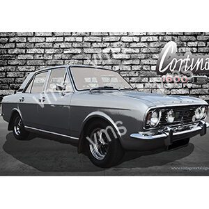 Classic silver coupe car parked against a brick wall.