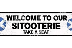 A black and white sign saying 'Welcome to our Sitooterie, Take a Seat'.