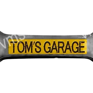 A wrench with "TOM'S GARAGE" on a yellow label.