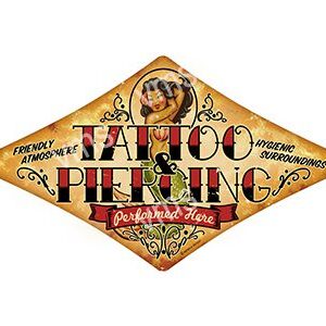 Vintage sign for Tattoo Piercing with decorative elements.