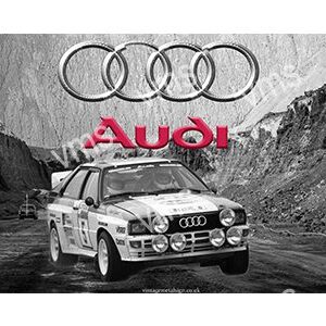 Classic Audi rally car racing on a rugged dirt road.