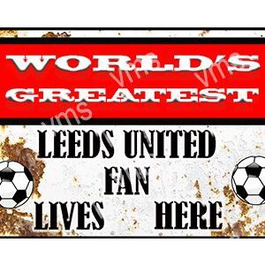 A sign that reads 'World's Greatest Leeds United Fan Lives Here' with soccer ball graphics.