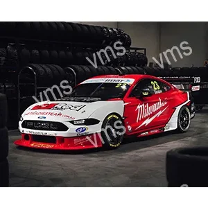 Milwaukee-branded race car in a garage with spare tires.
