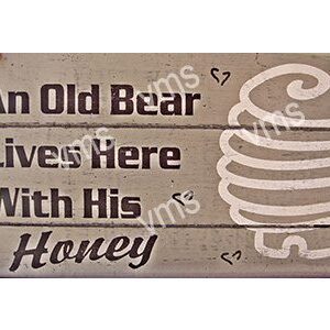 Rustic wooden sign about a bear and honey.