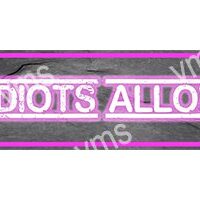 Neon sign reading 'IDIOTS ALLOWED' with a pink glow.