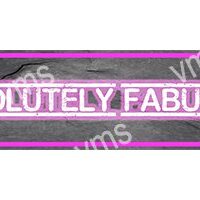 Neon sign reading 'ABSOLUTELY FABU' in pink light on a wooden background.