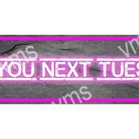 Neon sign reading 'YOU NEXT TUES' in pink light.