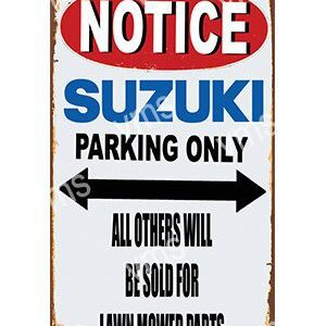 A Suzuki parking notice sign with directional arrows and a warning about unauthorized vehicles.