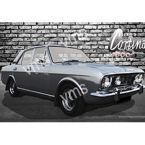 Classic silver coupe car parked against a brick wall.