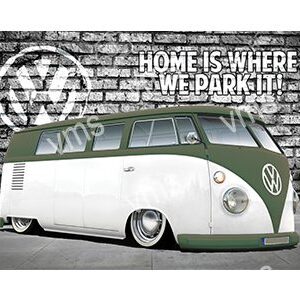 Retro white and green Volkswagen van with a low stance parked in front of a graffiti wall.