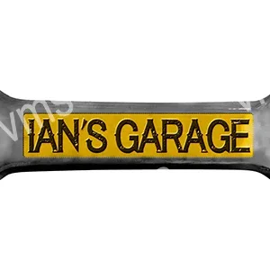 A rectangular pillow with the text 'IAN'S GARAGE' in black on a yellow background.