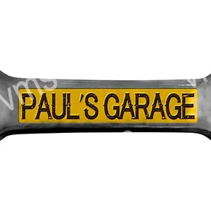 A yellow and black sign that reads Paul's Garage.