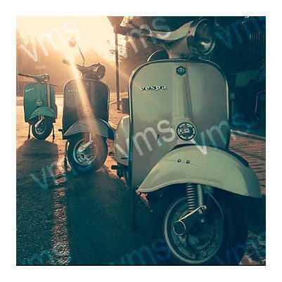 Vintage scooters parked together in a dimly lit area.